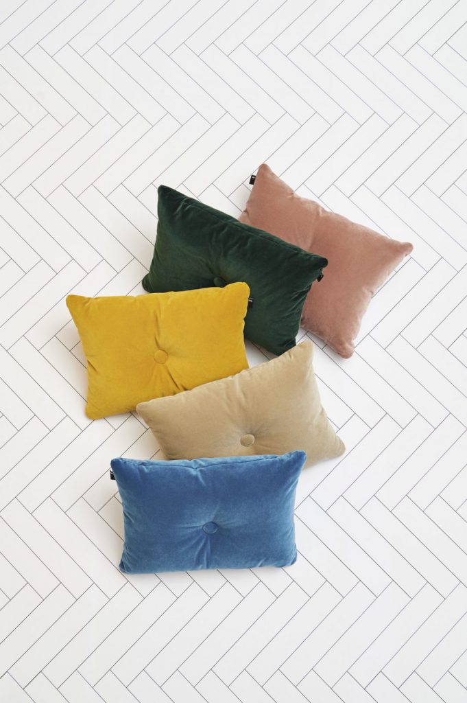 Un groupe d'oreillers colorés sur un sol blanc.