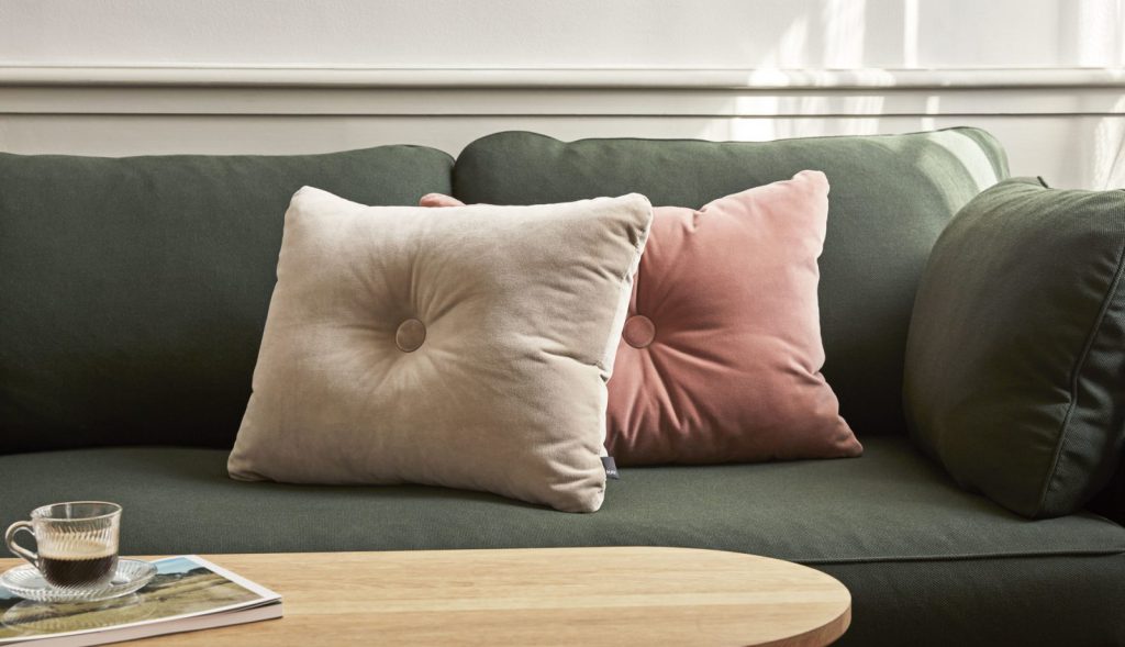 Deux oreillers sur un canapé vert.