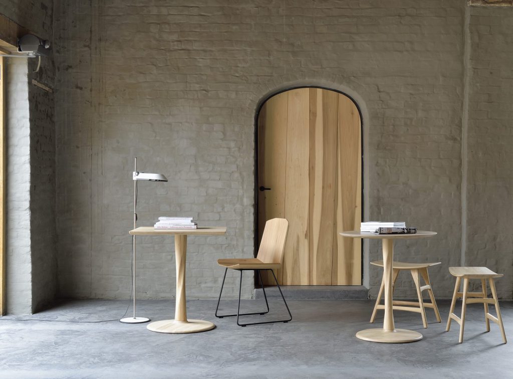 Une table et des chaises en bois dans une pièce avec un mur de briques.