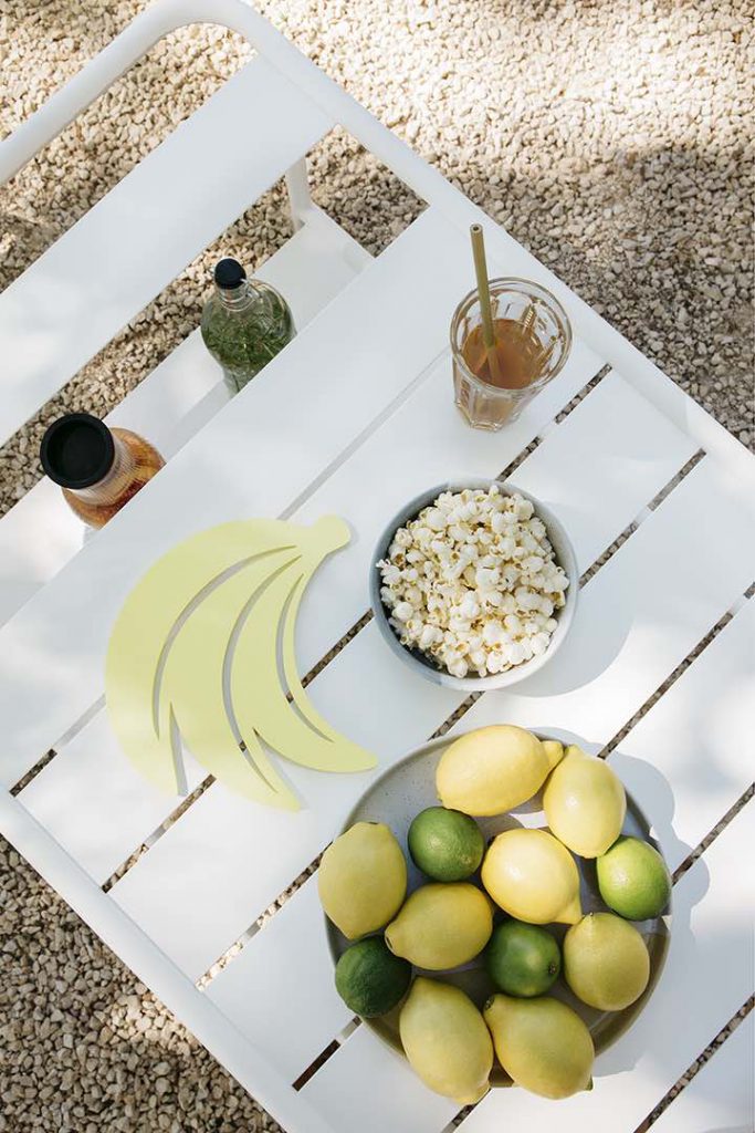 Une table blanche avec des citrons et des bananes dessus.