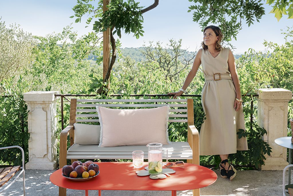 Une femme debout sur un banc à côté d’une table.