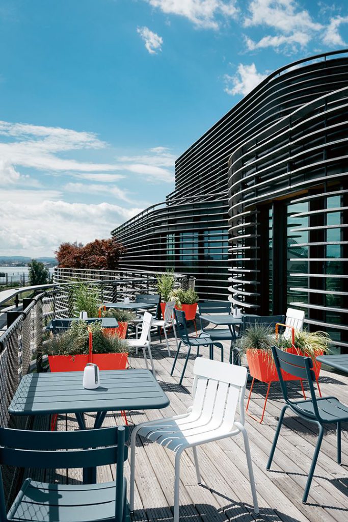 Un patio avec chaises et tables avec vue sur l'océan.