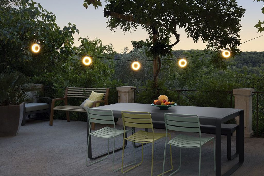 Une table et des chaises sur un patio au crépuscule.