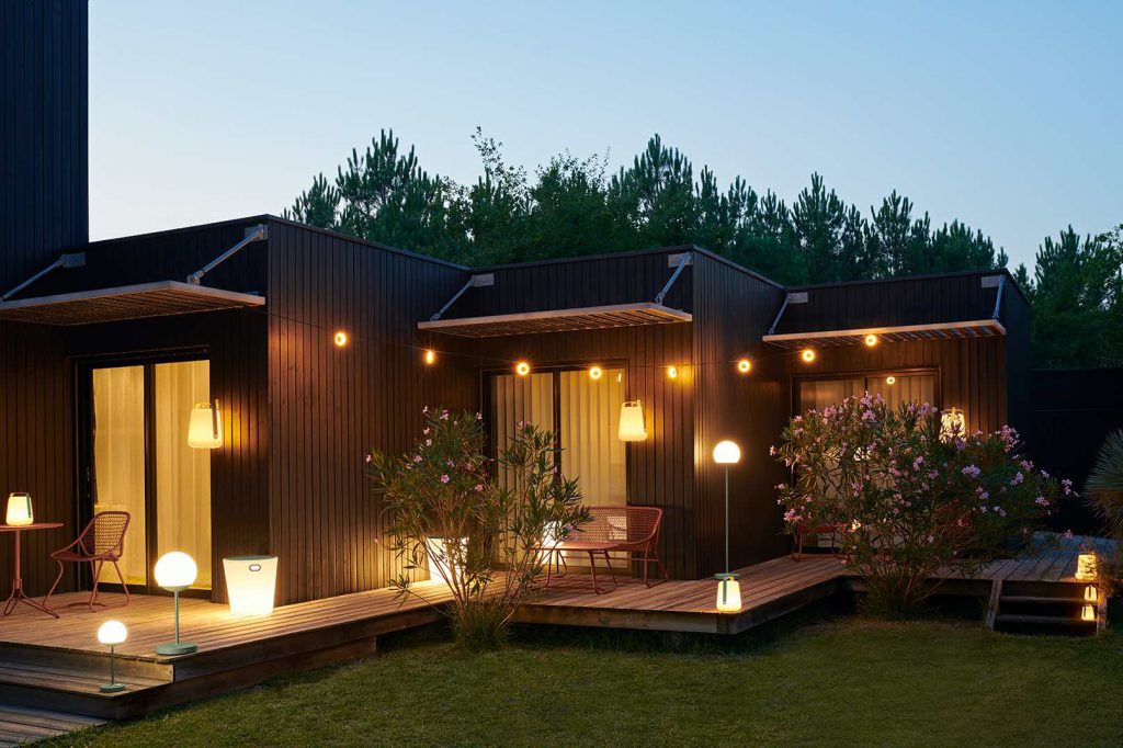Une petite maison éclairée la nuit avec des bougies.