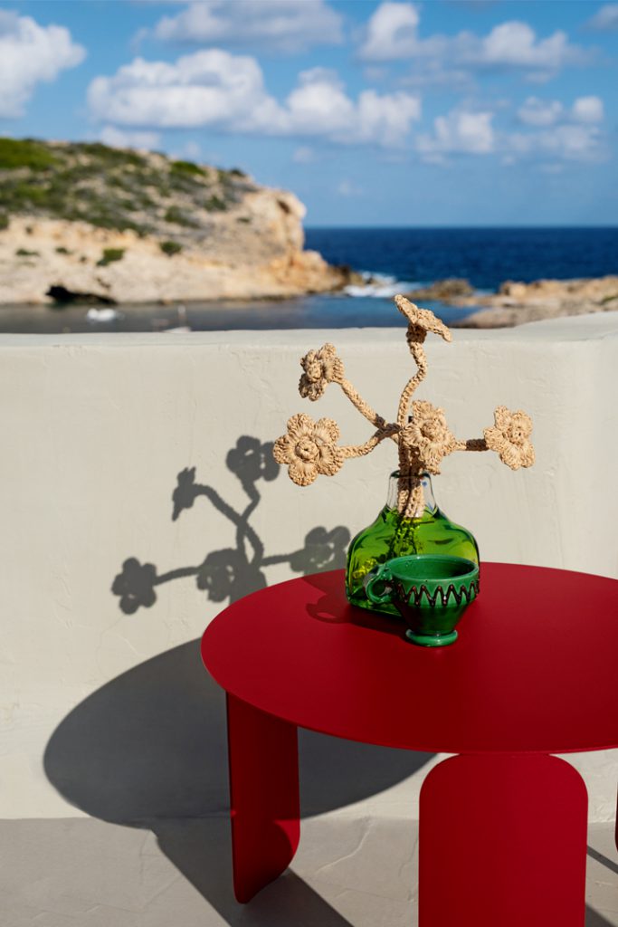 Une table rouge avec une fleur dessus.