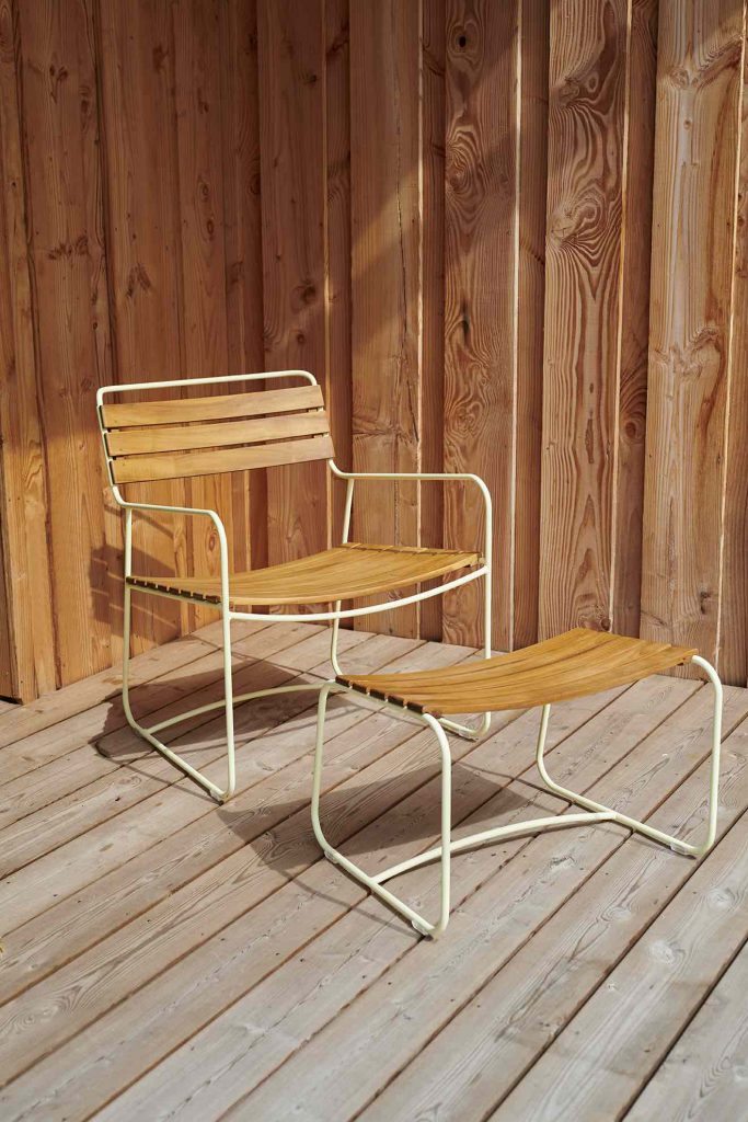 Une chaise et un pouf en bois sur une terrasse en bois.