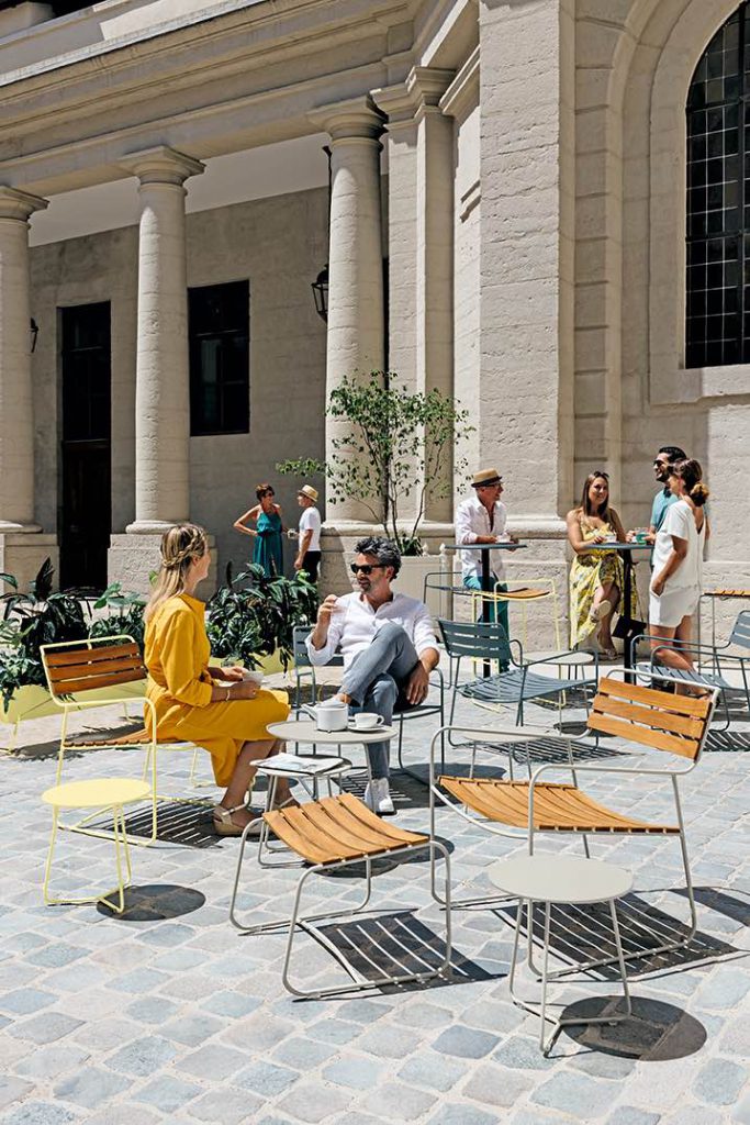 Un groupe de personnes assises dans une cour devant un immeuble.