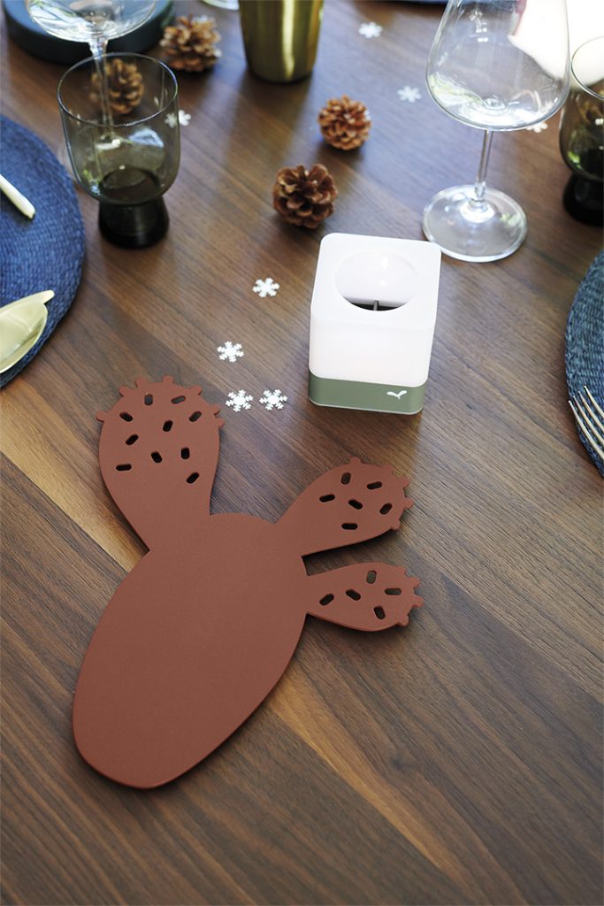Une table en bois avec un set de table en forme de cactus.