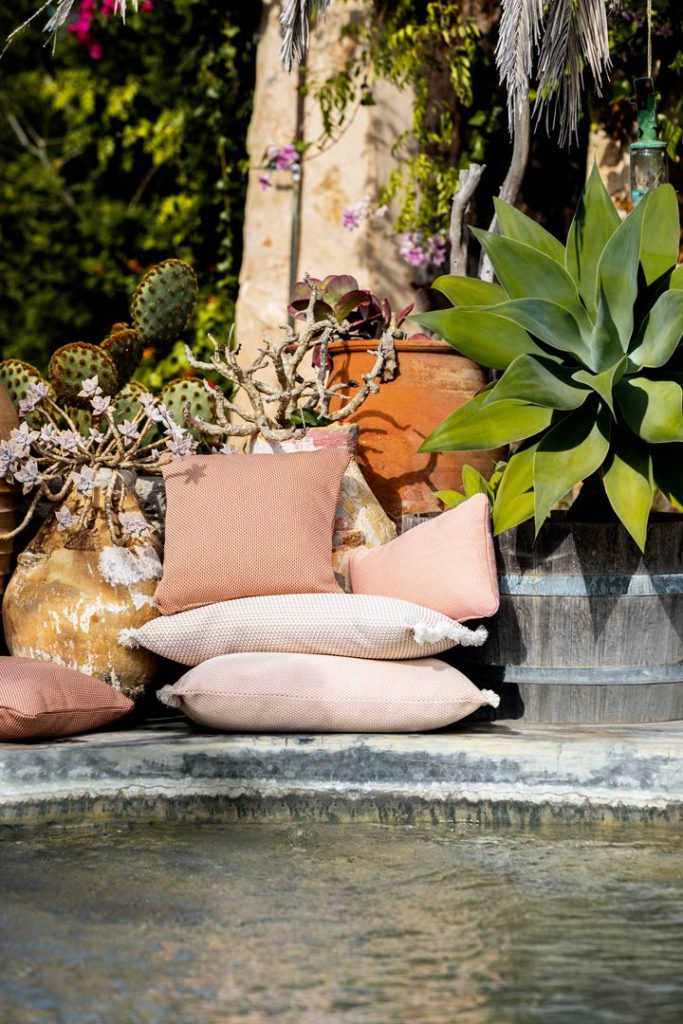 Un groupe d'oreillers sur un rebord à côté d'une piscine.