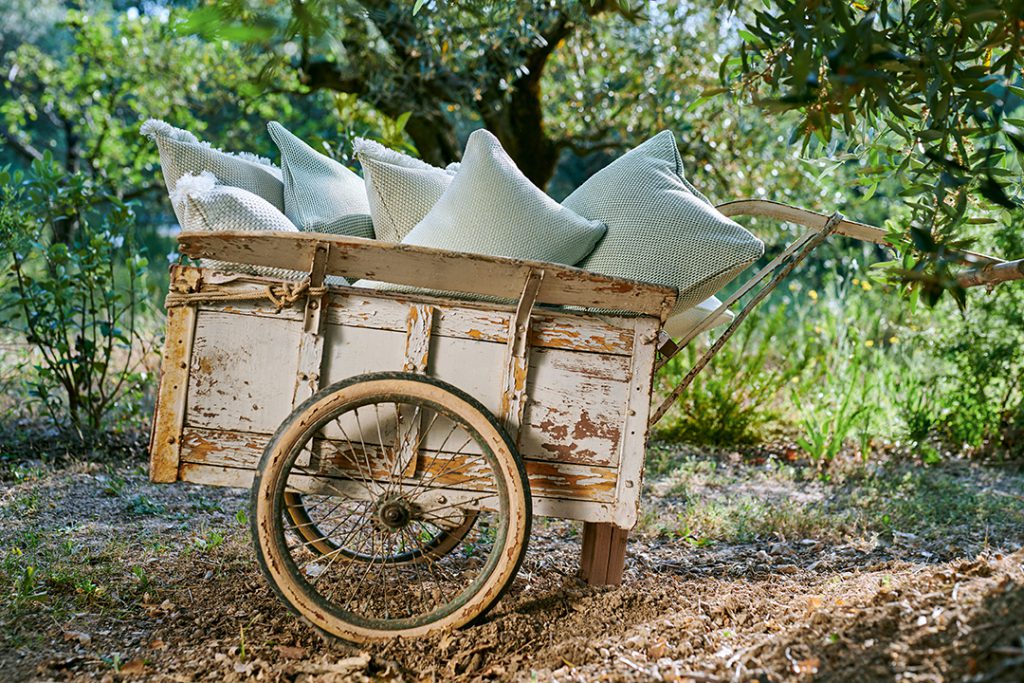 Un chariot en bois avec des oreillers dessus.