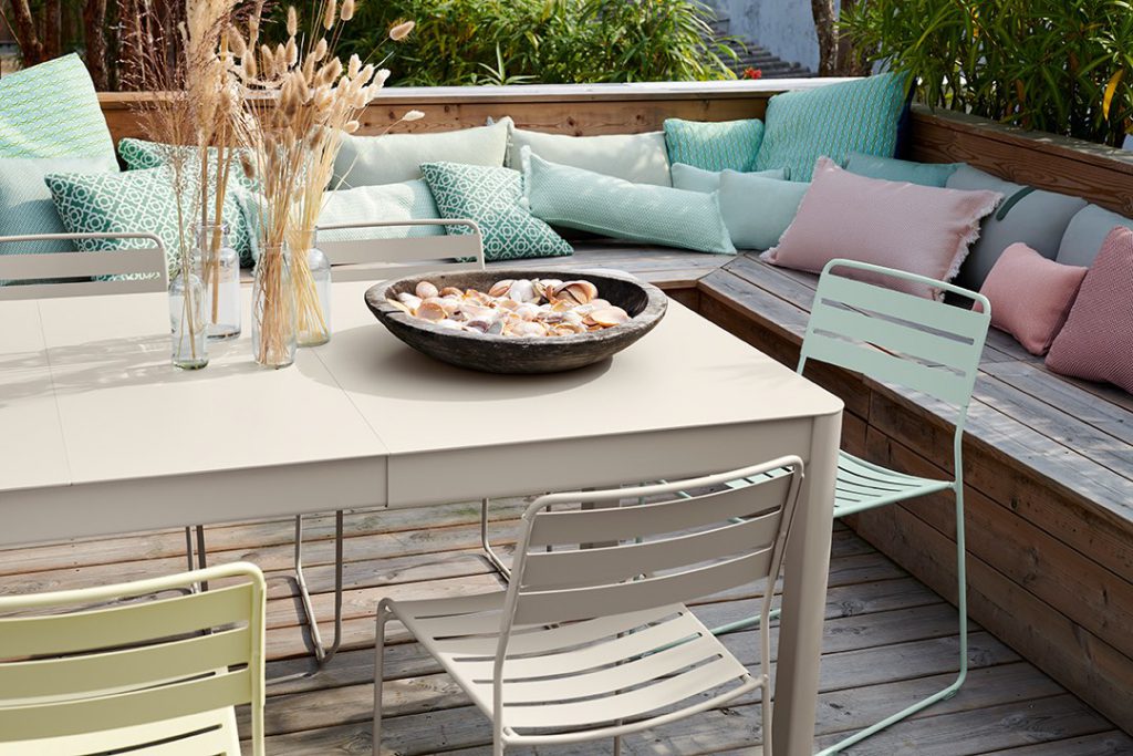 Une table et des chaises sur une terrasse en bois.