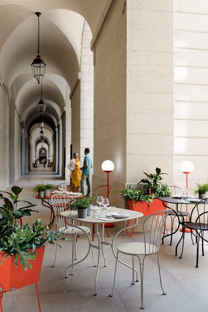 Un groupe de tables et de chaises dans une cour.