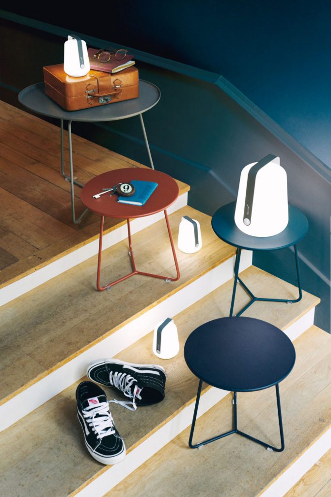 Une table avec une lampe dessus et une paire de baskets dessus.