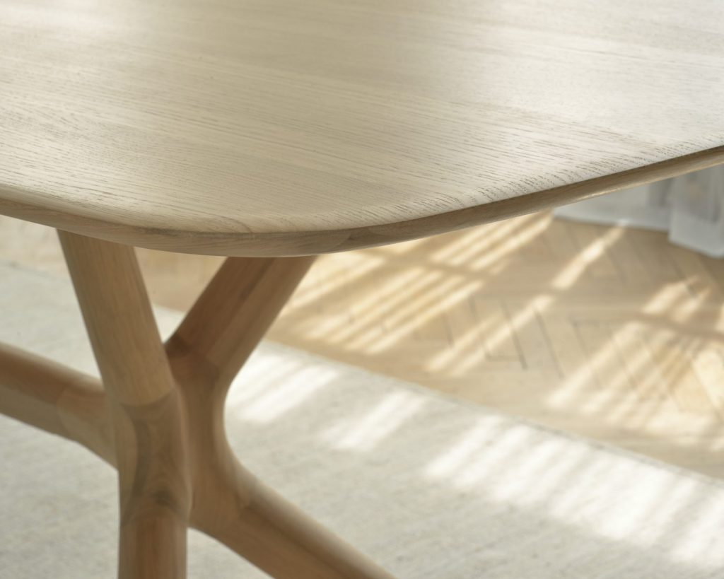 Une table à manger avec un plateau et des pieds en bois.