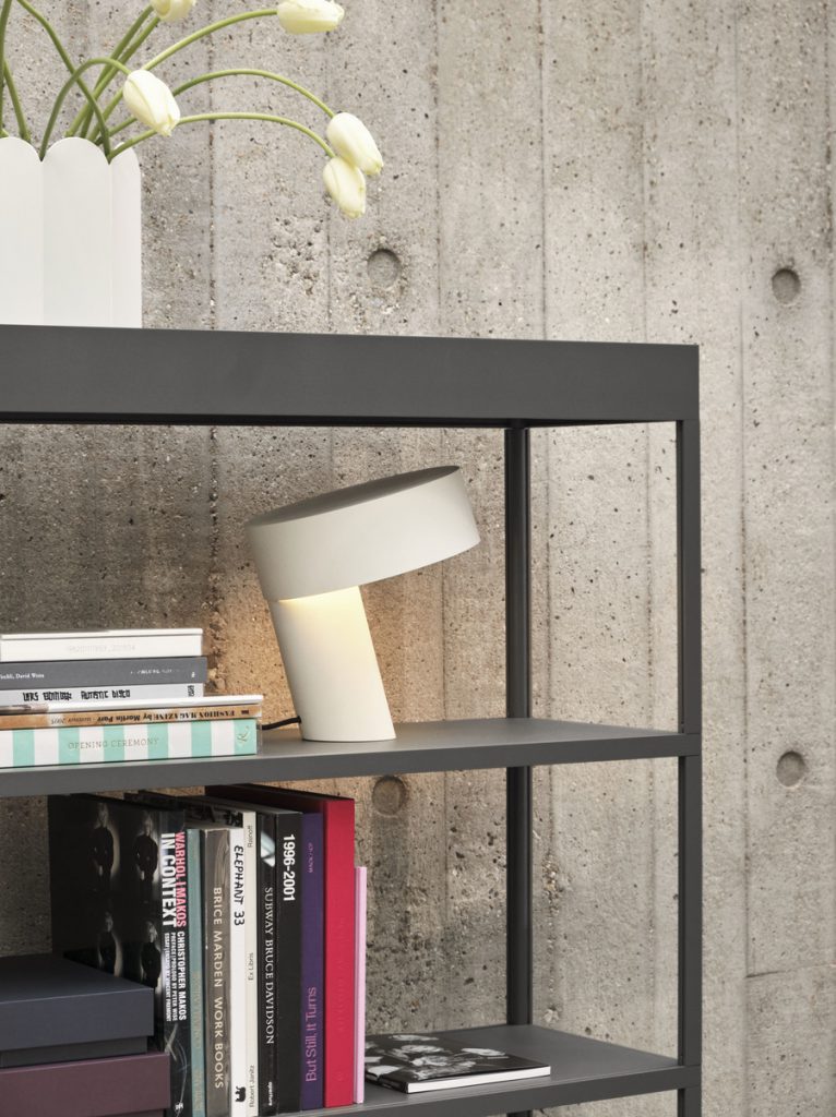 Une étagère avec des livres et des fleurs.