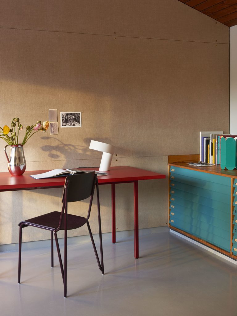 Un bureau dans une pièce avec un vase de fleurs.