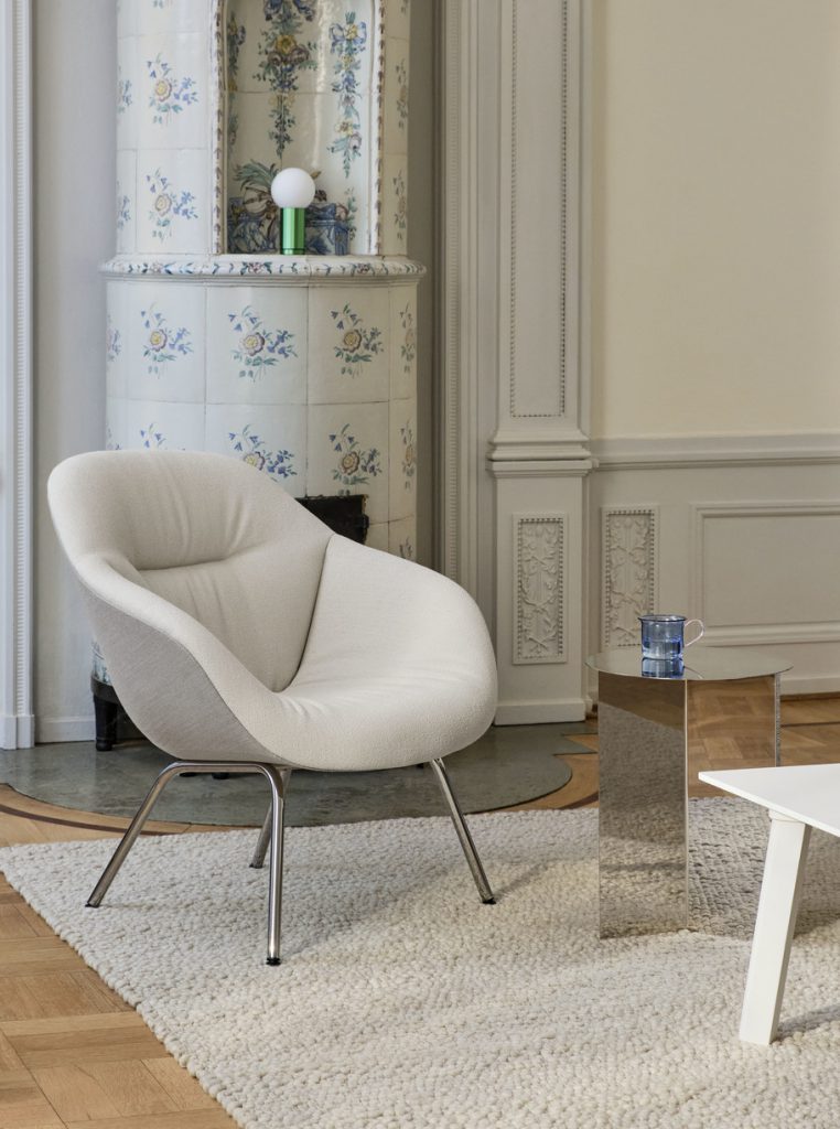 Un salon avec une chaise blanche et une table basse.