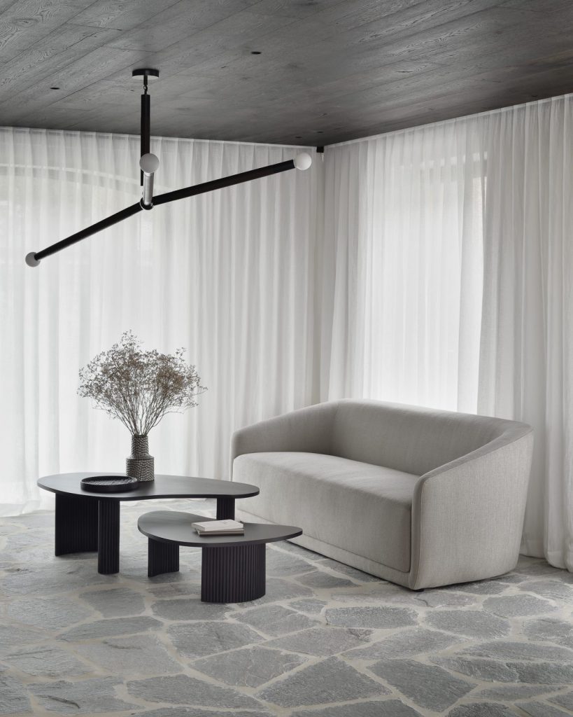 Un salon avec un canapé et une table blancs.