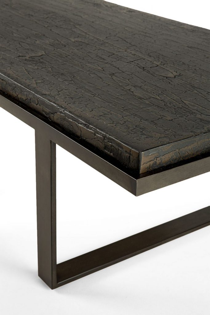 Une table basse noire avec une structure en métal.