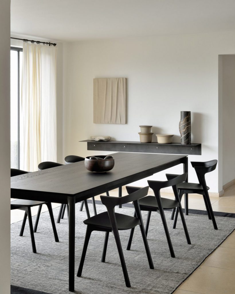 Une salle à manger moderne avec une table et des chaises noires.