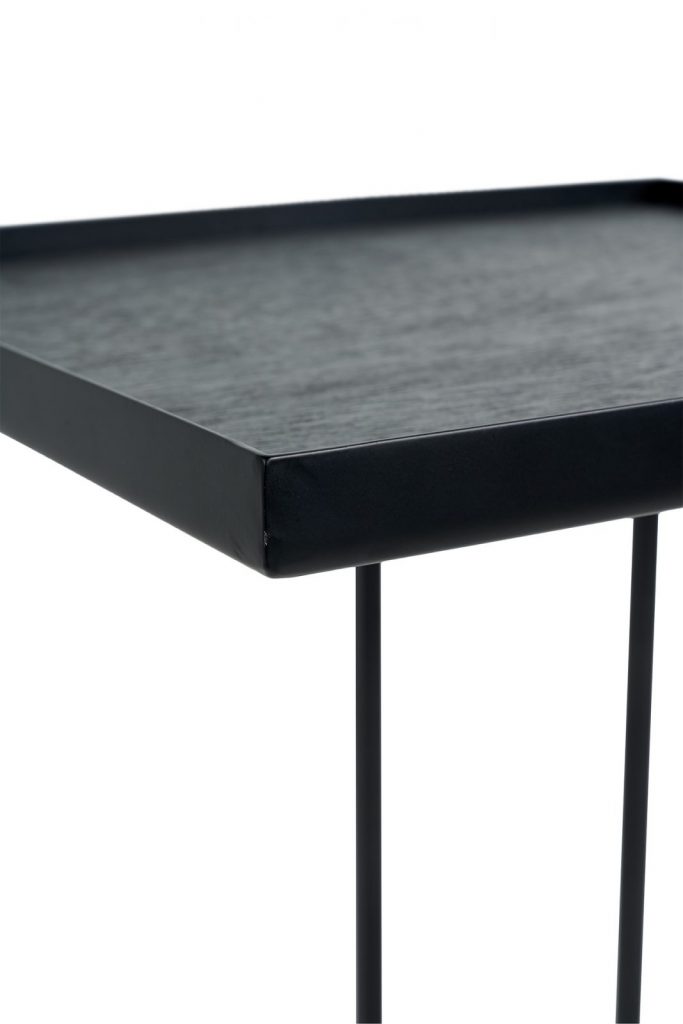 Une table d'appoint noire avec pieds en métal.