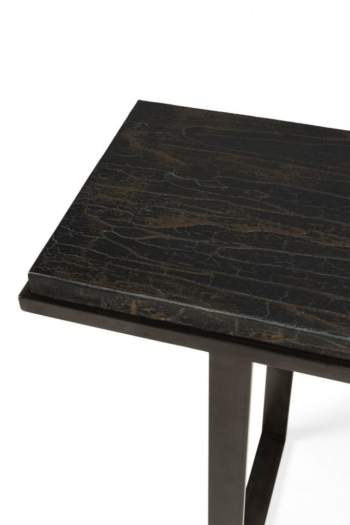 Une table en marbre noir avec un piètement en métal.