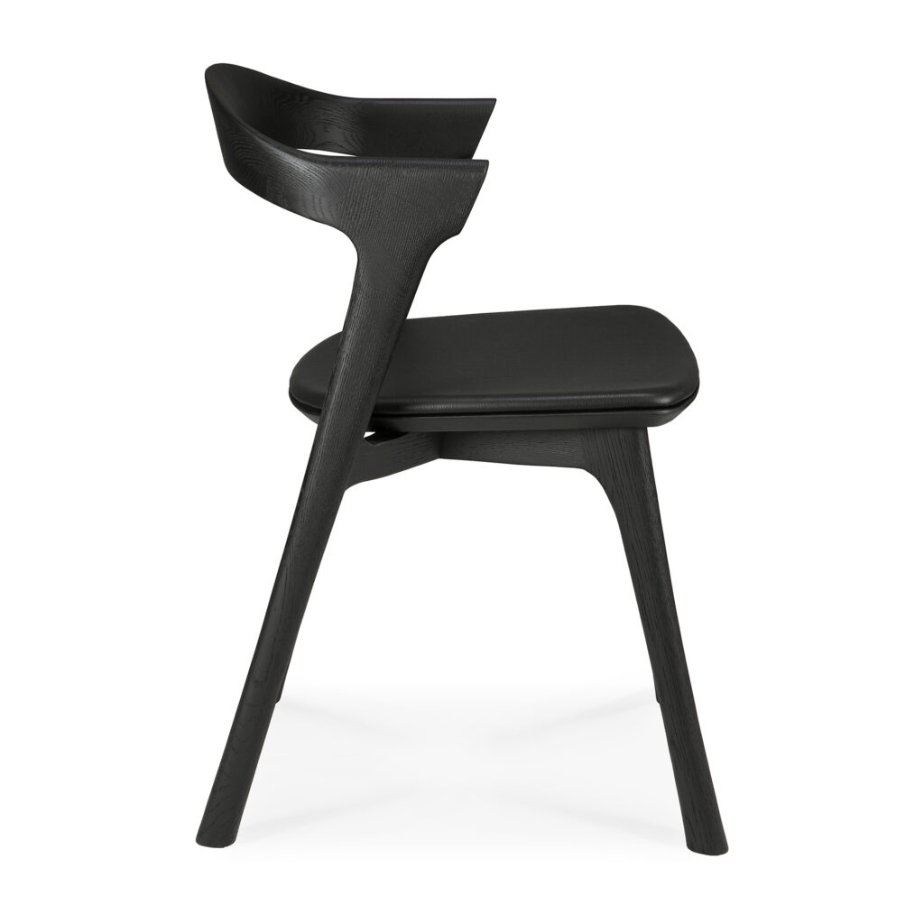 Vue latérale de la Chaise Bok en chêne noir, assise en cuir, une chaise moderne en bois noir en chêne avec un dossier incurvé, une assise inclinée et trois pieds, parfaite pour les intérieurs contemporains.