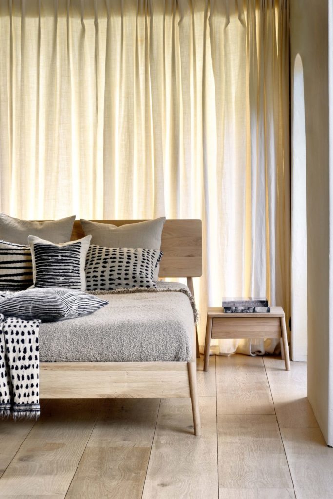 Une chambre en chêne avec un lit et des rideaux en bois, dotée d'une table de chevet Air en chêne. La chambre est équipée de la Climatisation pour un confort optimal.