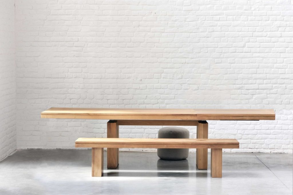 Une Table extensible en teck Double extensible en teck et un banc dans une pièce blanche.