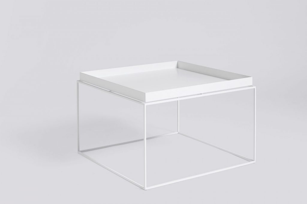 Une table d'appoint blanche avec un plateau sur le dessus.
