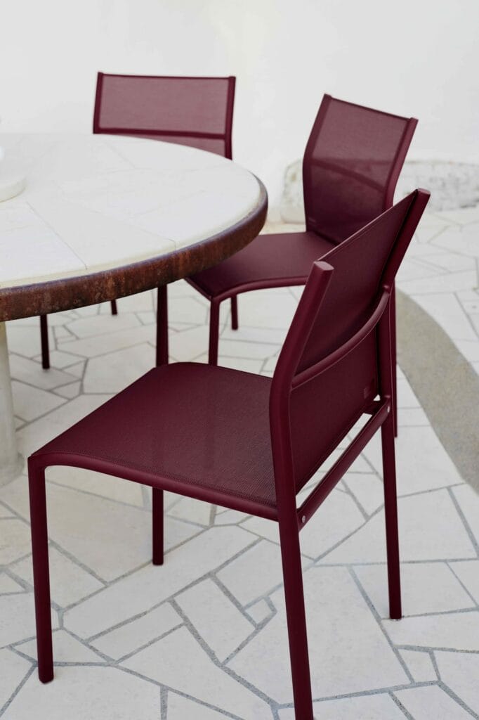 Deux chaises Chaise Cadiz marron avec une table ronde sur un patio carrelé.