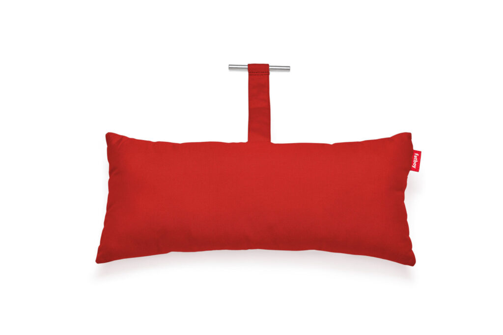 Le Coussin Headdemock Superb est un coussin rectangulaire rouge avec une petite étiquette en tissu et une poignée attachée avec une barre métallique, présentée sur un fond blanc.