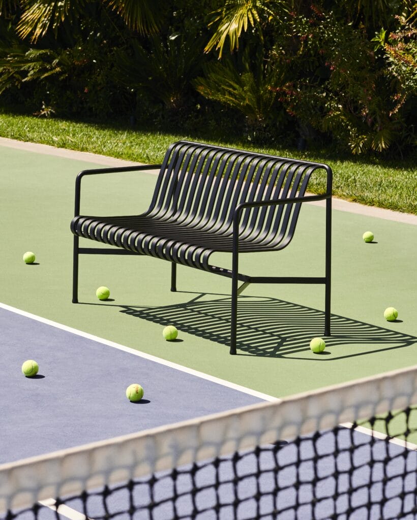 Un banc palissade de tennis avec dossier et accoudoirs.