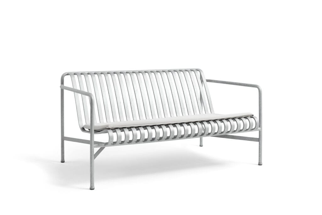 Un banc blanc avec un coussin blanc sur fond blanc.