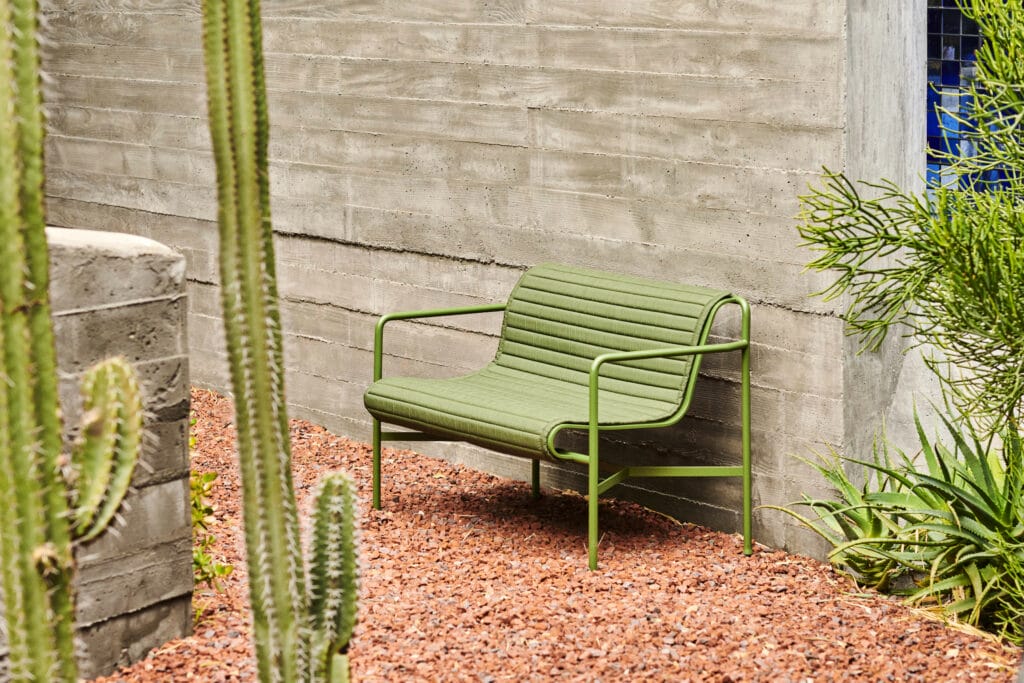 Un coussin matelassé pour banc Palissade à côté d'un cactus.