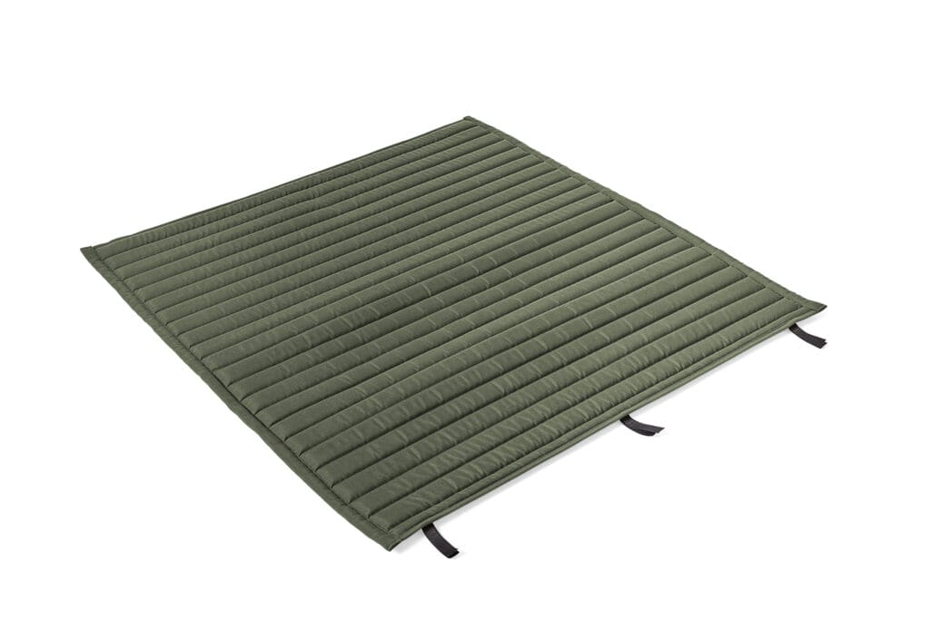 Un tapis matelassé vert sur fond blanc.