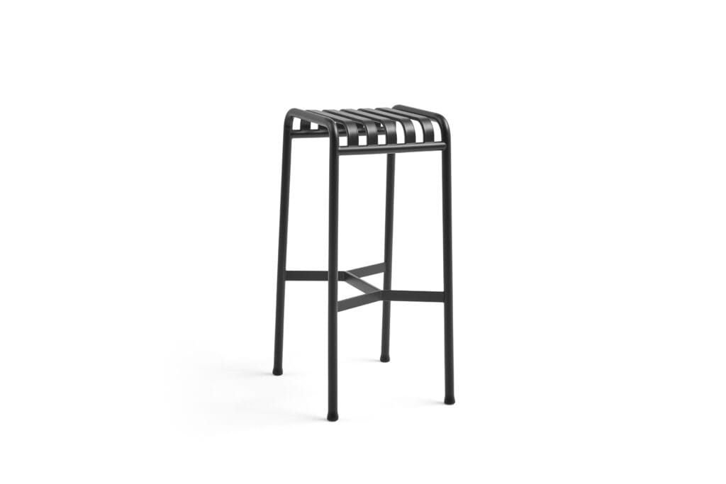 Un tabouret en métal anthracite sur fond blanc.