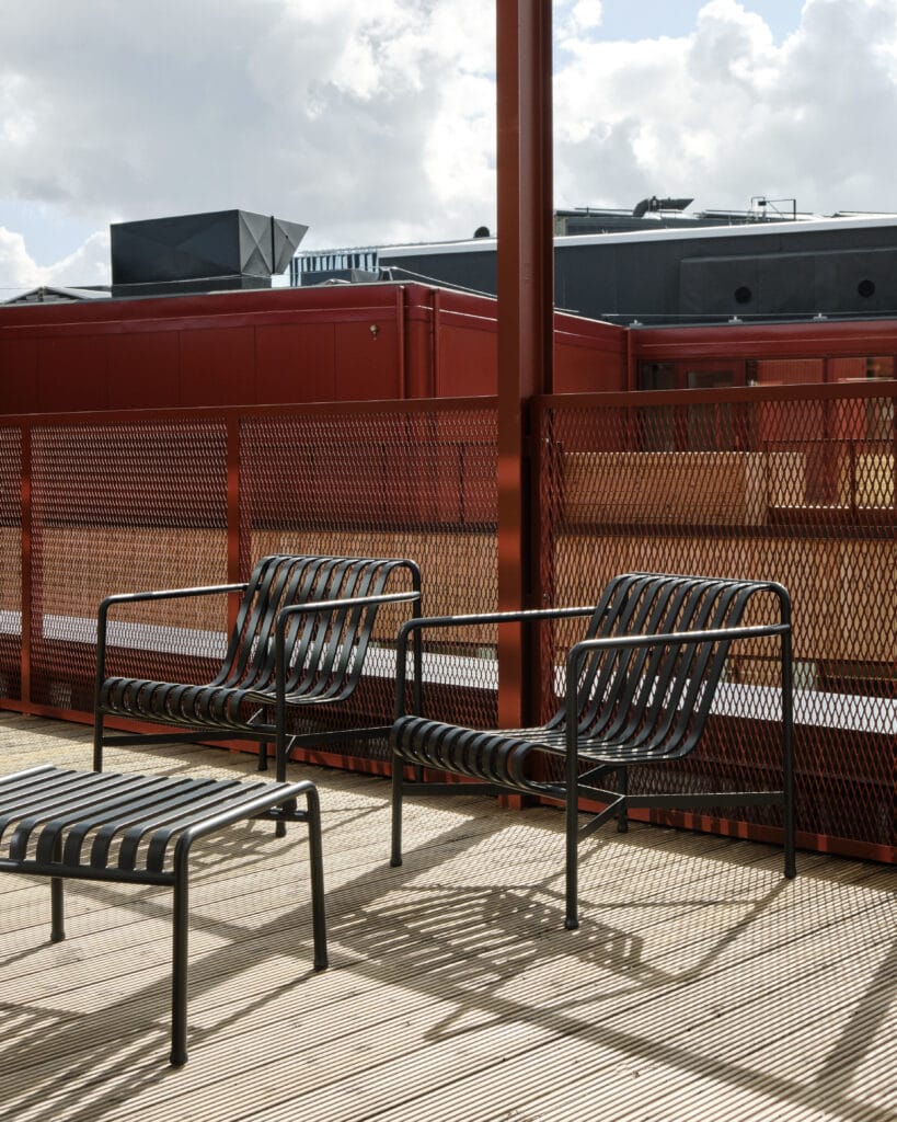 Une terrasse en bois avec une table et des chaises dotées de repose-pieds.