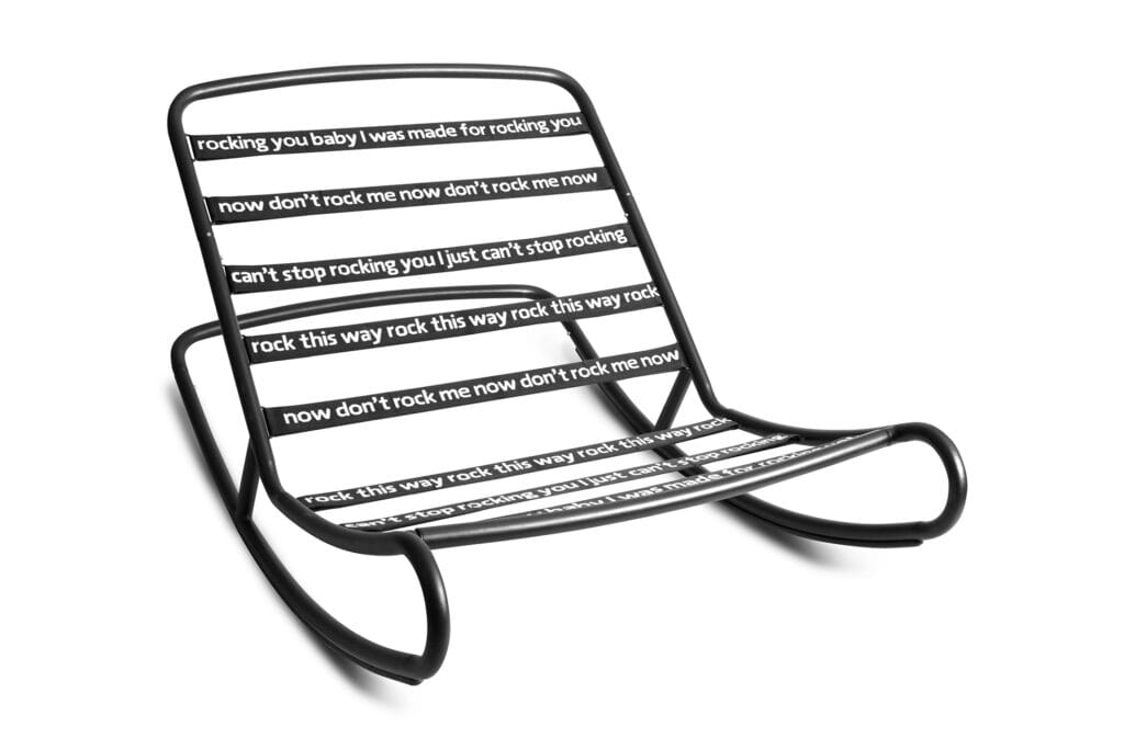 Une chaise à bascule noire d'inspiration Rock'n Roll, sur laquelle sont écrits des mots élégamment écrits.