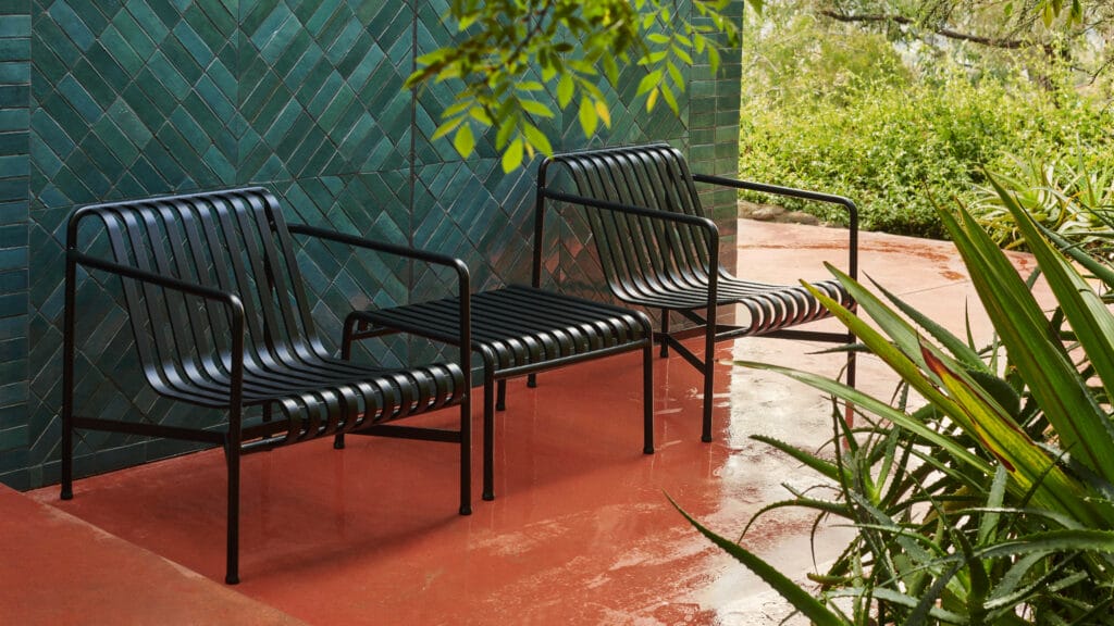 Deux chaises en métal anthracite sur une terrasse carrelée.