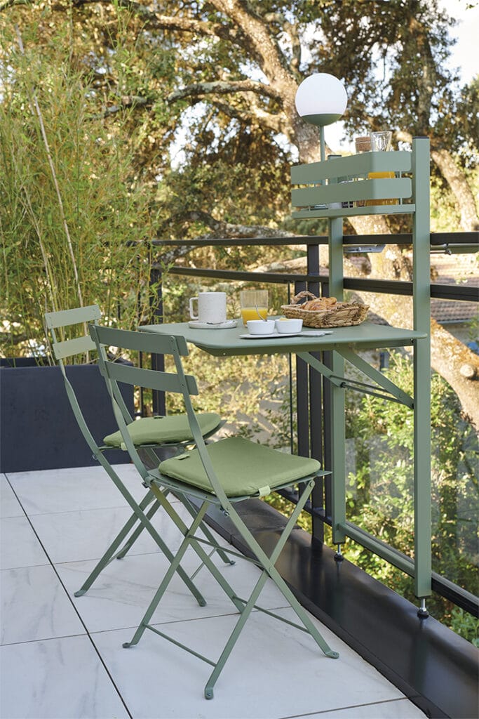 Une Table pliante Bistro verte pour balcon et des chaises pliantes sur un balcon.