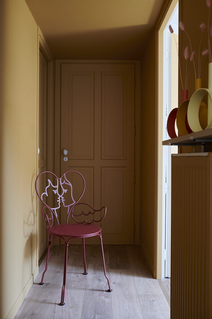 Une chambre avec une chaise ange près d'une fenêtre.