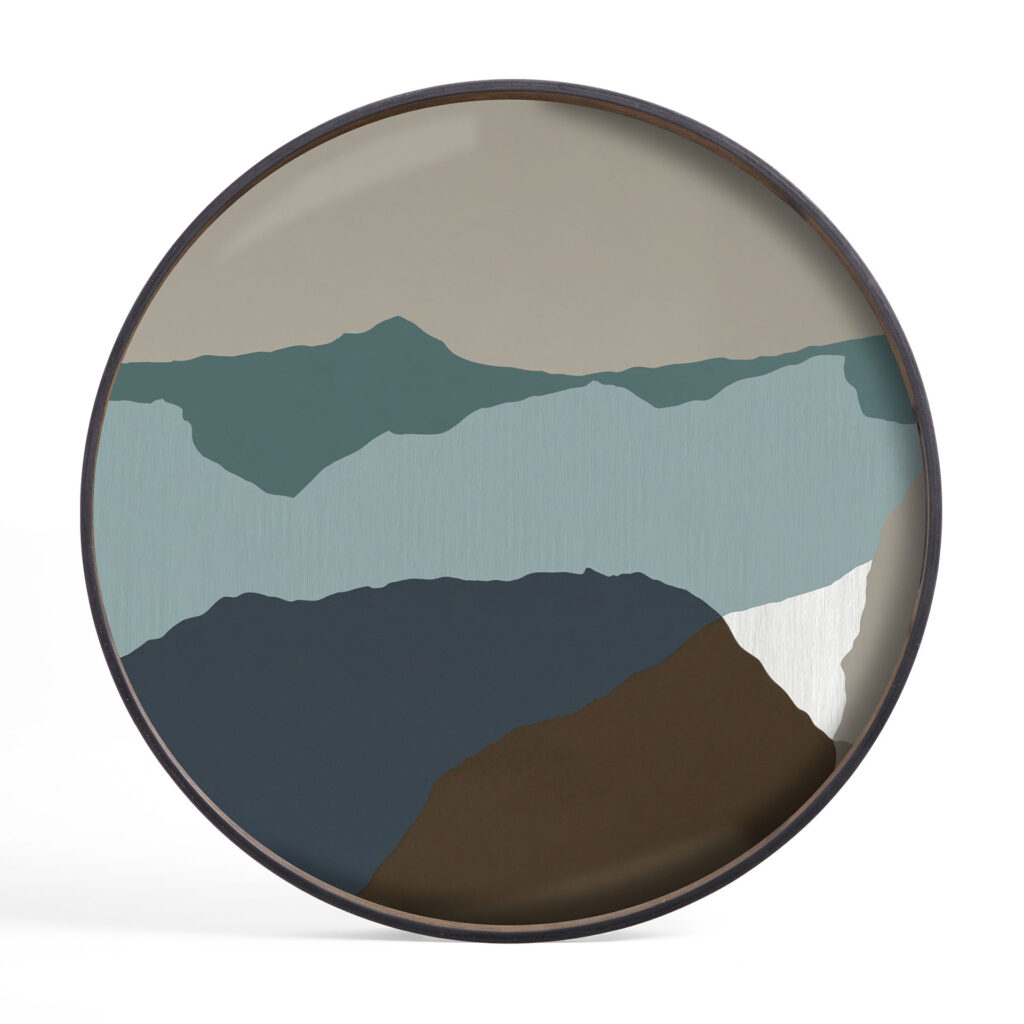 Le « Plateau rond Graphite Wabi Sabi XL » est un plateau rond extra-large orné de motifs montagneux abstraits dans des tons de bleu, vert, beige et blanc, incarnant l'esthétique Wabi Sabi avec ses douces imperfections.