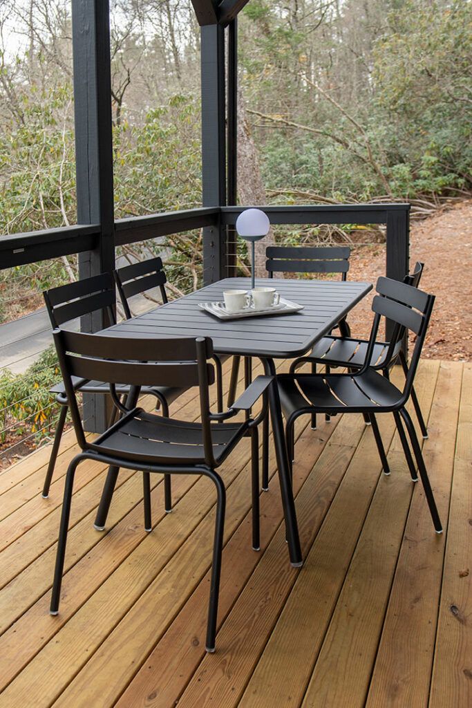 Une terrasse en bois avec une table et Fauteuil Luxembourg.