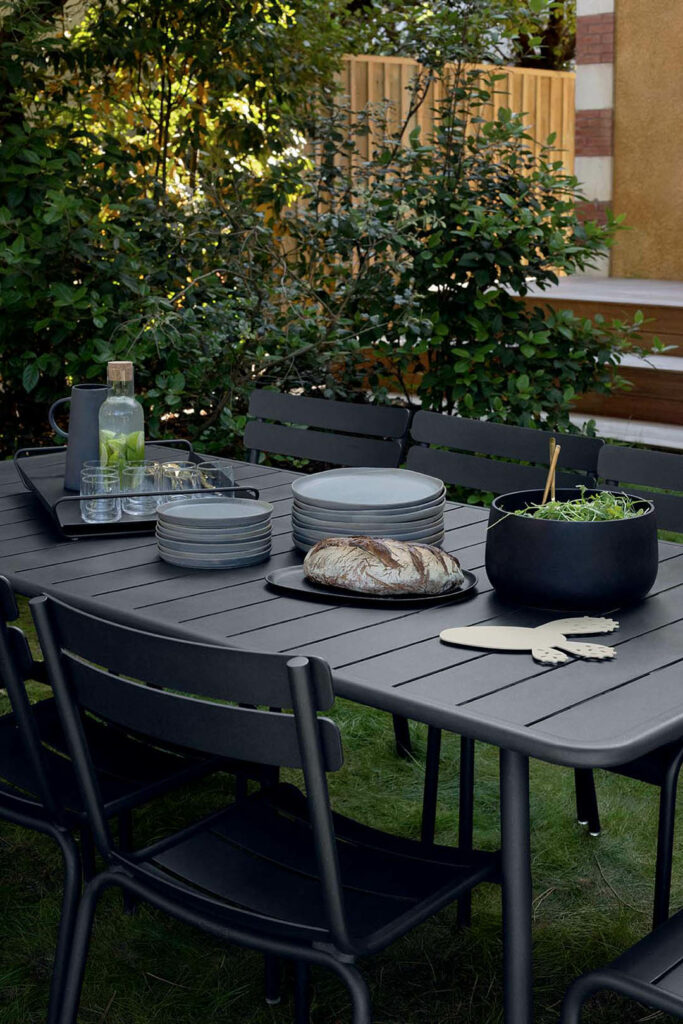 Une Table Luxembourg noire, 207 x 100 cm dans un jardin.