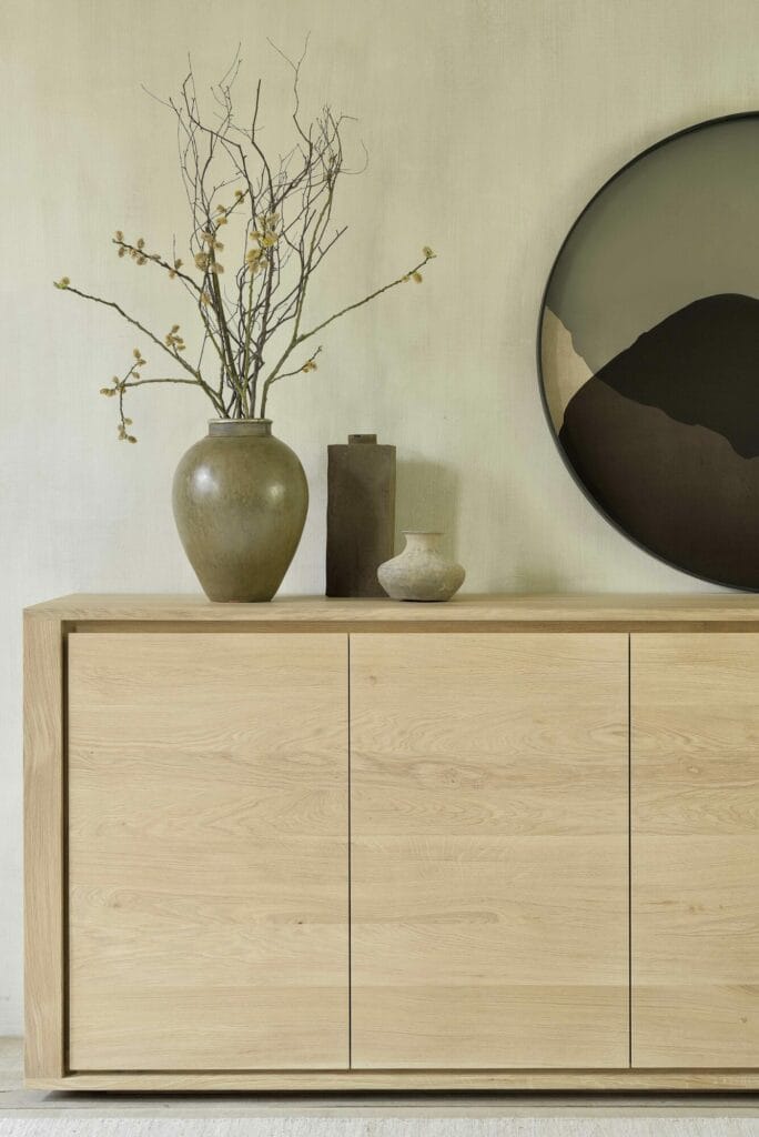 Un Dressoir Shadow en chêne 3 portes avec un vase rempli d'ombre devant lui.