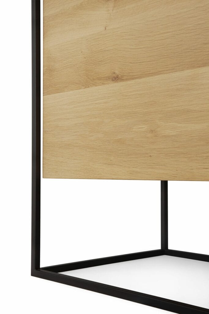 Une table d'appoint Buffet Monolit en chêne à cadre noir.