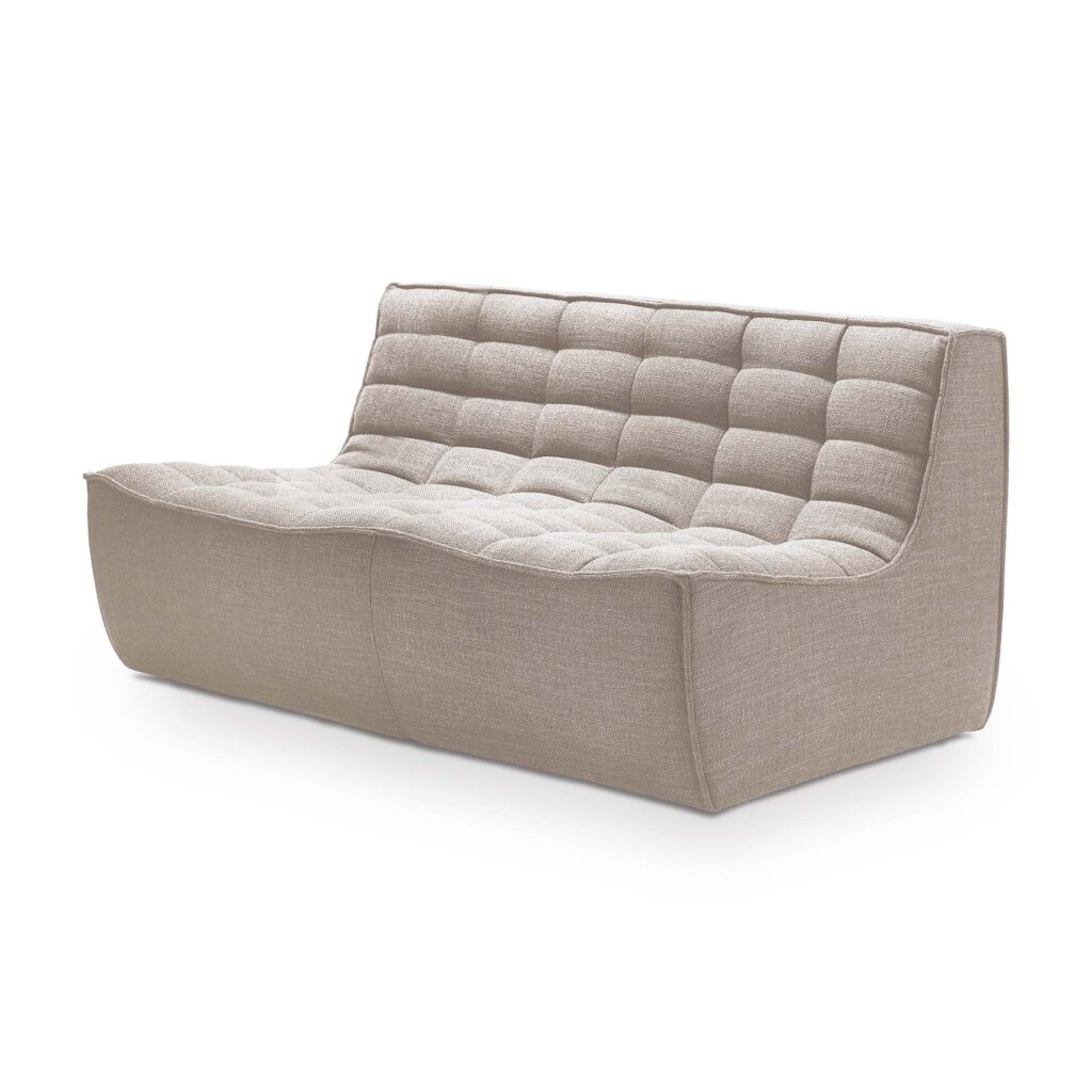 Le Canapé N701, 2 places est un canapé beige moderne avec un dossier bas, un design matelassé et des lignes douces et incurvées pour un confort contemporain.