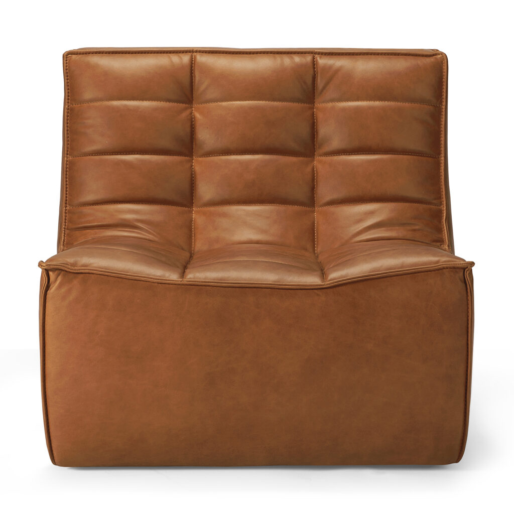 Un fauteuil Canapé N701 en cuir marron avec des coussins touffus carrés en cuir aniline luxueux et un design sans accoudoirs, à profil bas, vu de face - parfait pour 1 place.