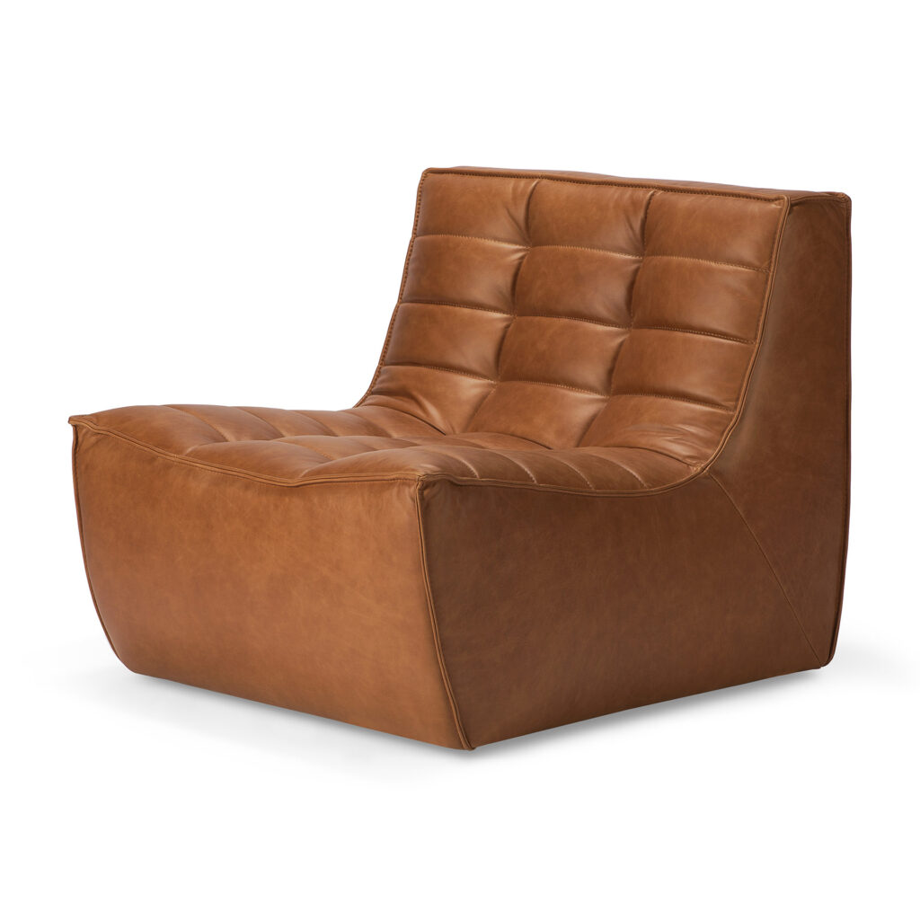 Ce fauteuil moderne sans accoudoirs, inspiré du Canapé N701, se caractérise par un revêtement en cuir aniline marron tufté et une assise basse et large, parfaite pour 1 place.